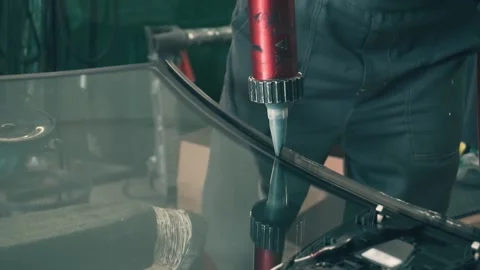 Process of preparing windshield for replacement in car service. Worker applies Stock Footage 169524522