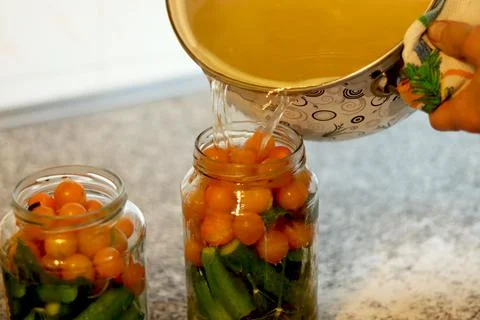 The process of preserving cucumbers and tomatoes for the winter. selective fo Stock Photos