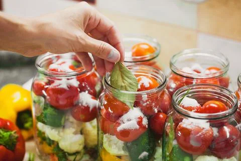 The process of preserving cucumbers and tomatoes for the winter. Stock Photos