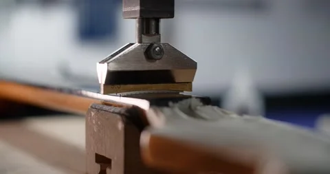 Process of press fitting the frets into the guitar fretboard at the luthier's Stock Footage 166218598