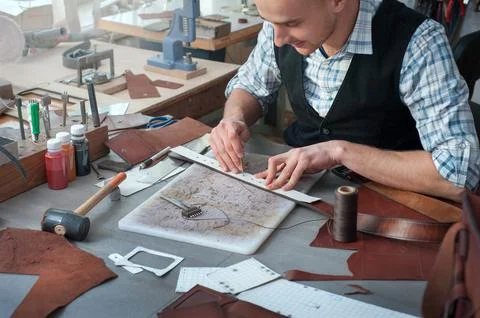 The process of punching holes in the belt with patterns and markings, a clo.. Stock Photos