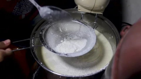 The process of putting flour into the cake dough Stock Footage 272285443