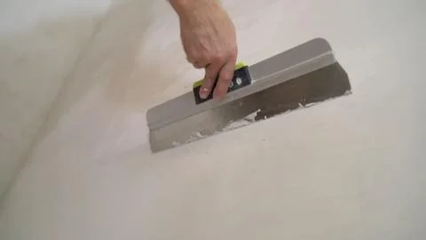 The process of putty the walls with a large spatula. Stock Photos