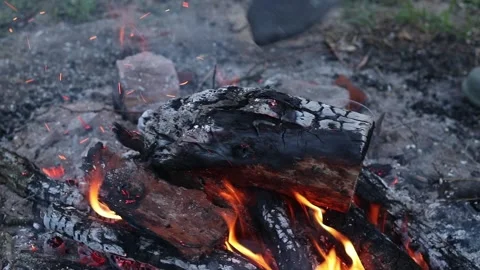 The process of raking coals in a bonfire with a metal shovel Stock Footage 336798451