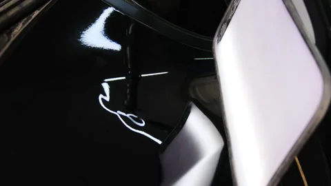 Process of removing dent from surface of car body in workshop Stock Footage 316175475