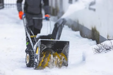 Process of removing snow with portable blower machine, worker dressed in over Stock Photos