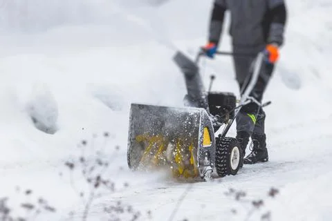 Process of removing snow with portable blower machine, worker dressed in over Stock Photos