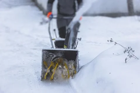 Process of removing snow with portable blower machine, worker dressed in over Stock Photos