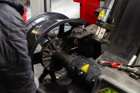 The process of repairing an automobile wheel using a special press on a machi Stock Photos