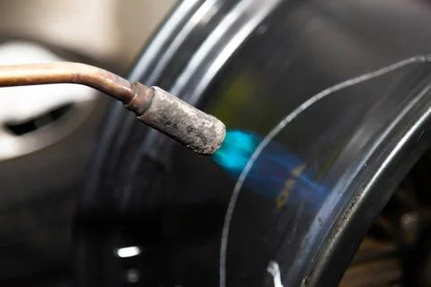 The process of repairing an automobile wheel using a special press on a machi Stock Photos