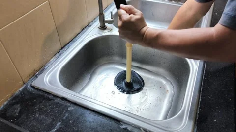 The process of repairing a kitchen sink that's clogged with food scraps and.. Stock Footage 338995631