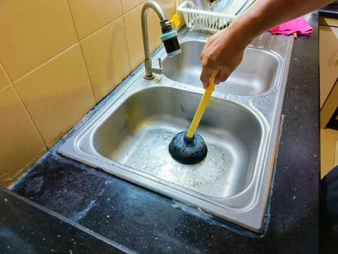 The process of repairing a kitchen sink that's clogged with food scraps and.. Фото