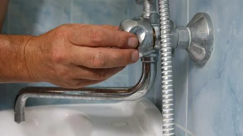 The process of repairing or adjusting a bathroom faucet Stock Photos