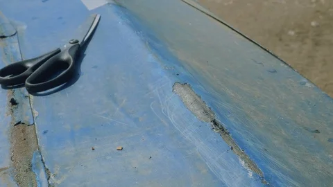 Process of reparing canoe. Man tapes hole on bottom of canoe Stock Footage 93806405