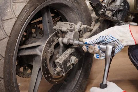 The process of replacing brake pads on a motorcycle. Stock Photos