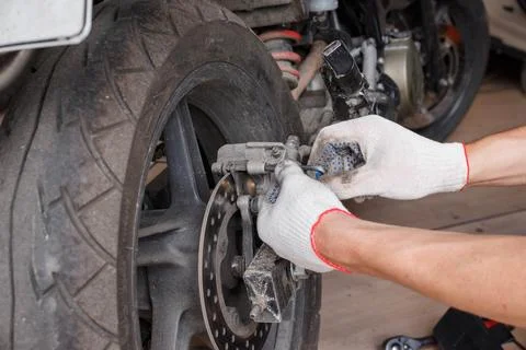 The process of replacing brake pads on a motorcycle. Stock Photos