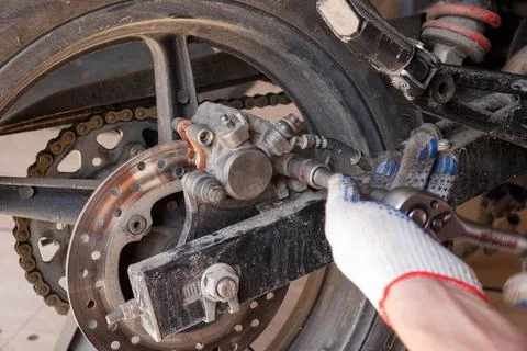 The process of replacing brake pads on a motorcycle. Stock Photos