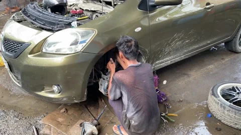 The process of replacing a car tire by a garage mechanic Stock Footage 235681368