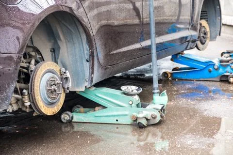 The process of replacing summer tires with winter tires. Stock Photos