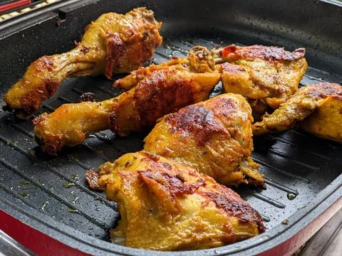 The process of roasting chicken meat in a grill pan Stock Photos