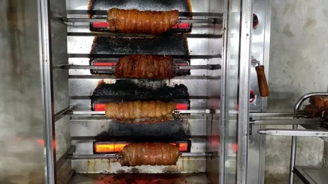 Process of roasting pork belly using a modern rotary rotisserie oven Stockbeeldmateriaal 346838142