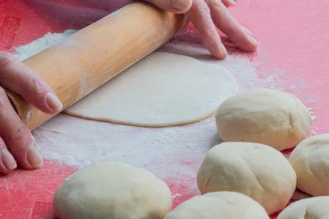 The process of rolling the dough with a wooden rolling pin, cooking bread at Stock Photos