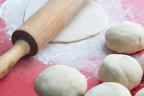 The process of rolling the dough with a wooden rolling pin, cooking bread at Stock Photos