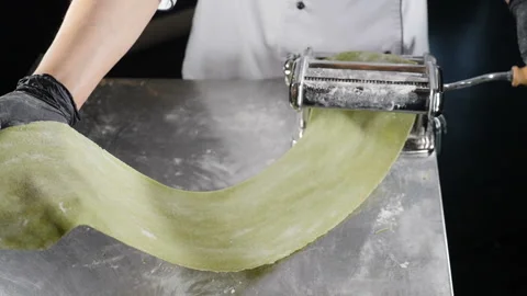 Process of rolling out dough for pasta on rolling machine. Female chef holding Video stock 142234915