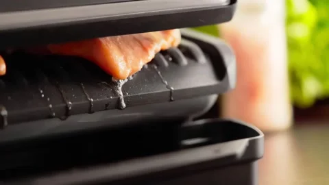Process of salmon cooking on electric grill with closed cover and drops of Stock Footage 223975106