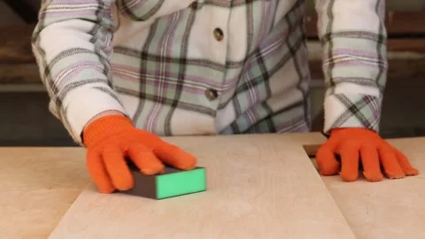 The process of sanding a wooden surface with a sanding block Vidéo 335475532