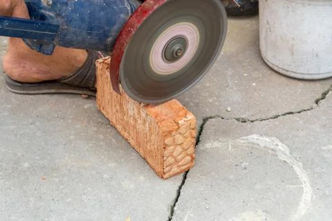 The process of sawing bricks with a grinder with a diamond disc Stock Photos
