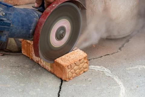 The process of sawing bricks with a grinder with a diamond disc Stock Photos