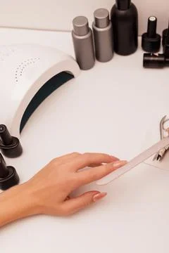 The process of sawing the nail with a nail file. Women's manicure at home Stock Photos