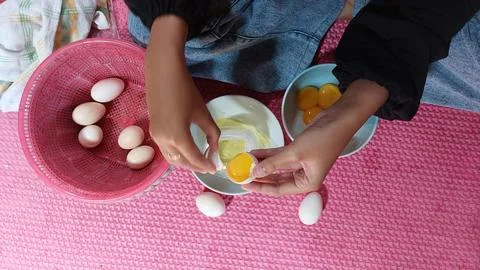 The process of separating egg yolks from egg whites to be used to make cakes 스톡 사진