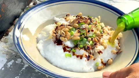 The process of serving chicken porridge (bubur ayam) Stock Footage 233272958