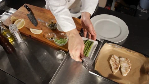 The process of serving grilled pike perch fillet with asparagus and lemon Stock Footage 116776409