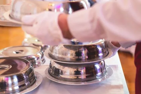 Process of serving luxury dinner in a cloche plate dish with a lid, waiter se Stock Photos