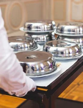 Process of serving luxury dinner in a cloche plate dish with a lid, waiter se Stock Photos