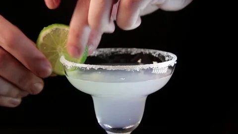 Process of serving margarita cocktail. Bartender pouring alcohol drink into a Stock Footage 85070675