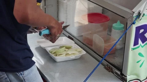 The process of serving rujak(fruit salad) by the seller to the buyer. Stock Footage 210373800