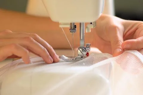 The process of sewing curtains from a mesh of white fabric. Close up view. Foto stock