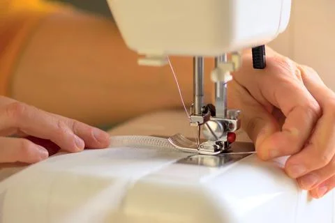 The process of sewing curtains from a mesh of white fabric. Close up view. Stock-Fotos
