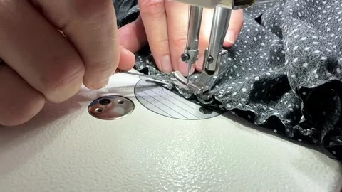 The process of sewing a dress. Close-up hands a seamstress guiding fabric Stock Footage 313005526