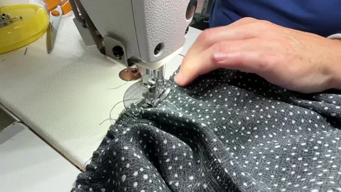 The process of sewing a dress. Close-up hands a seamstress guiding fabric Video stock 313005555