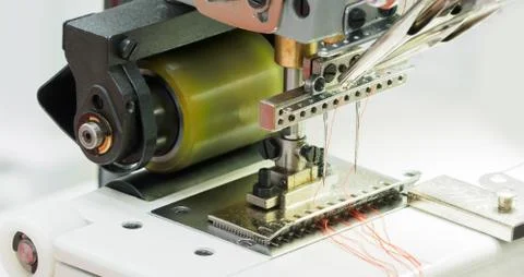 The process of sewing on the overlock in the garment shop. Stock Photos