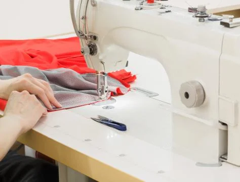 The process of sewing on the overlock in the sewing shop. Stock Photos