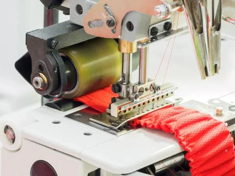 The process of sewing on the overlock in the sewing shop. Stock Photos