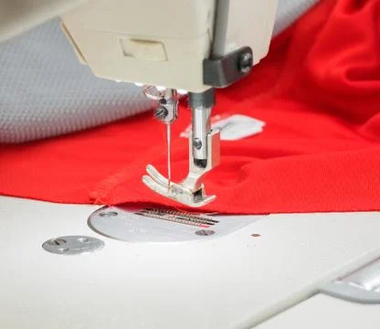 The process of sewing on the overlock in the sewing shop. Stock Photos