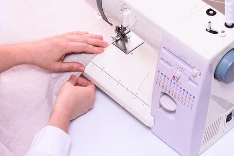 The process of sewing on a sewing machine. Stock Photos