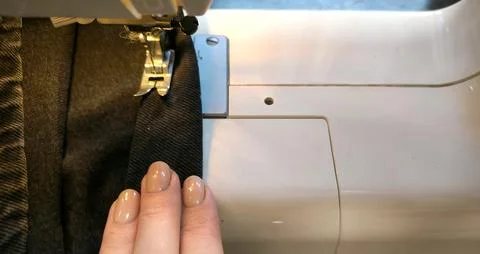 Process of sewing in a sewing machine sew woman's hands manicure black text.. Stock Photos